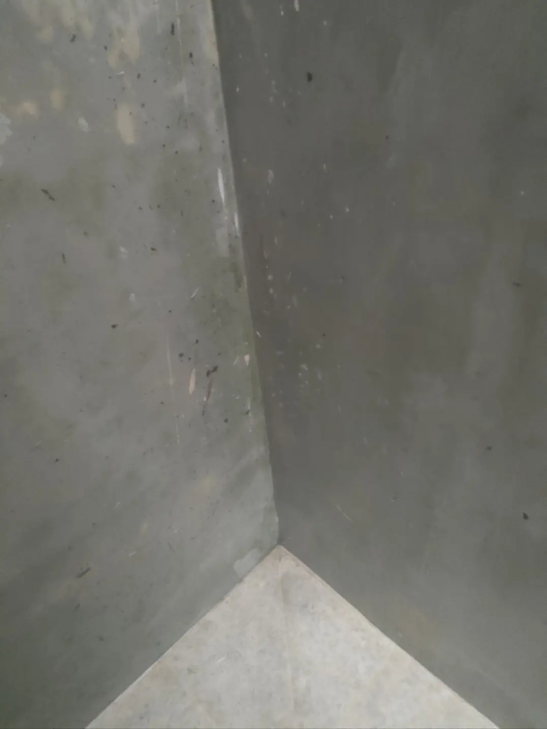 Le même angle de murs en béton propre après le nettoyage par Artisans L.L