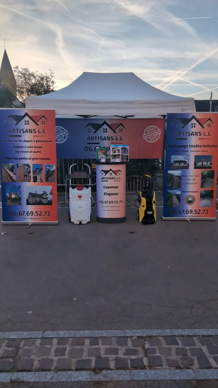 Le stand d’Artisans L.L : barnum, kakémonos bleu-blanc-rouge, nettoyeur haute pression et pulvérisateur